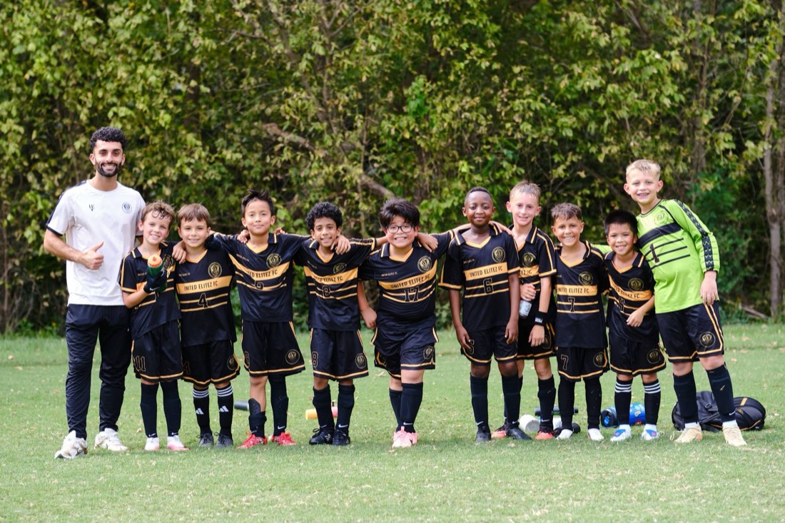 Coach Parsa and the United Elitez FC U10 Boys Travel team posing together on the field